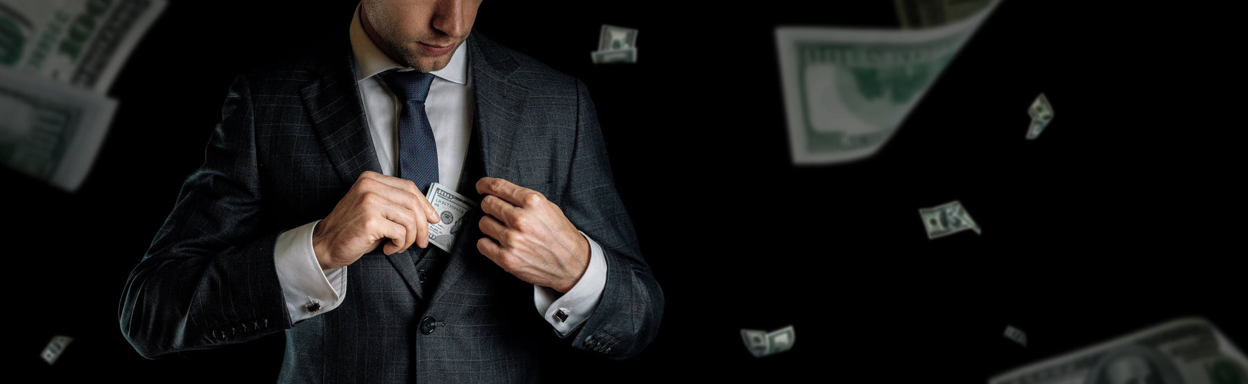 a mysterious man in a suit placing a wad of $100 bills in his inside pocket