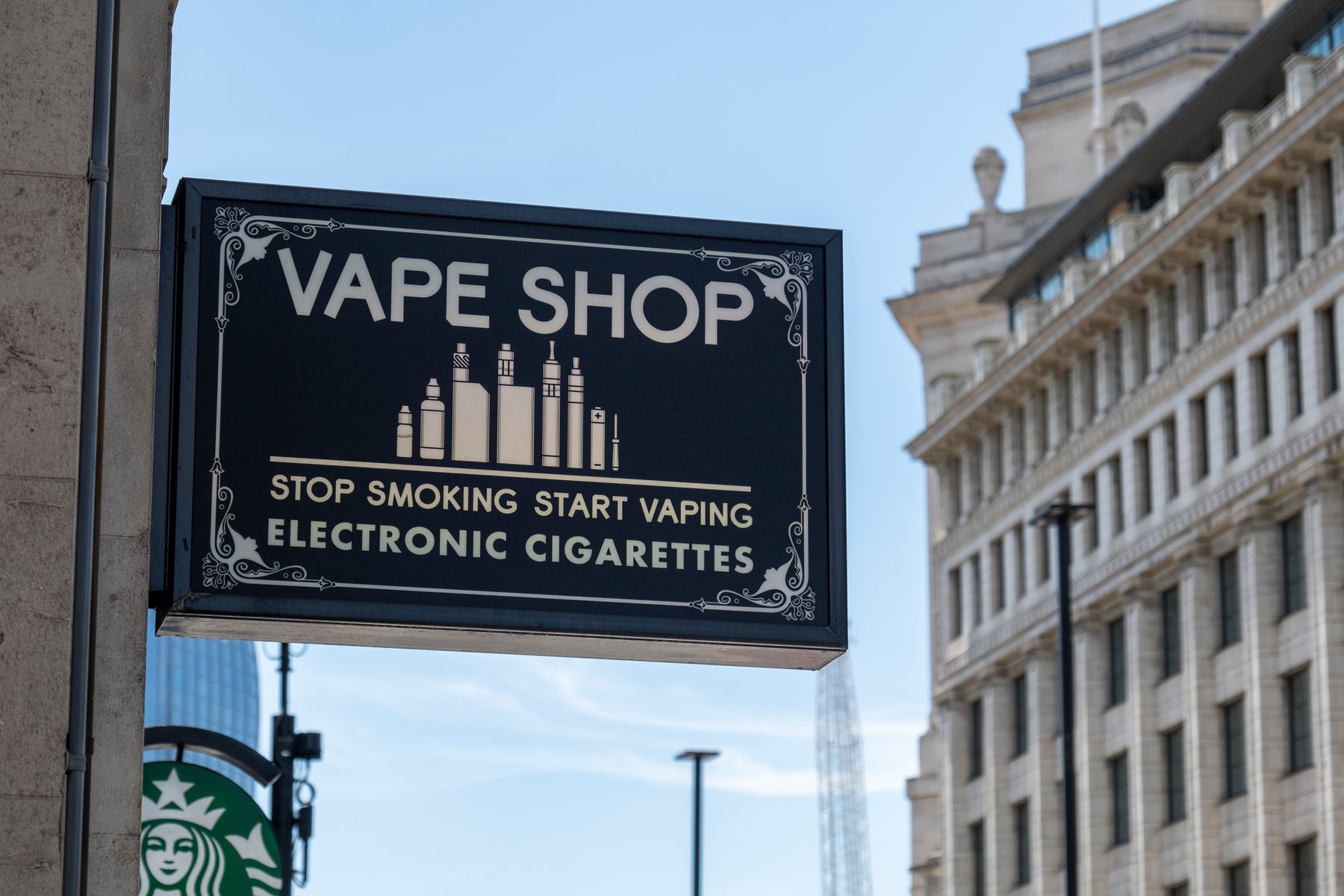 Black sign for a vape shop that includes the message Stop Smoking Start Vaping